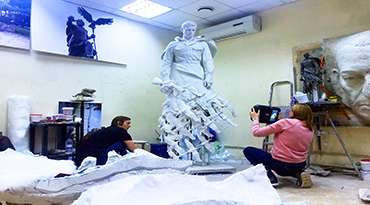 DRAKE HELPS THE SCULPTOR IN HIS WORK